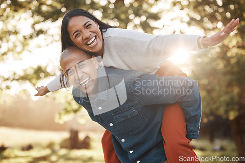 Image of Couple, park and happy with piggy back, portrait and airplane game in nature, holiday and bonding in summer. Man, woman and playful in backyard, freedom and vacation by trees with love in sunshine