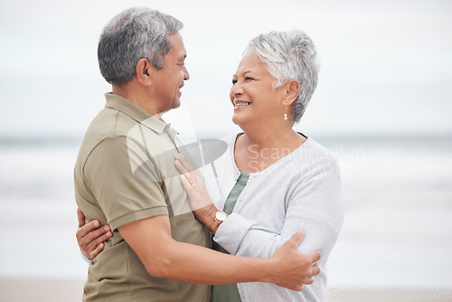 Image of Elderly, couple and hug with smile on beach in nature together for holiday, relax and connection outdoor. Commitment, man or woman with love embrace for peace, trust and vacation at ocean or sea