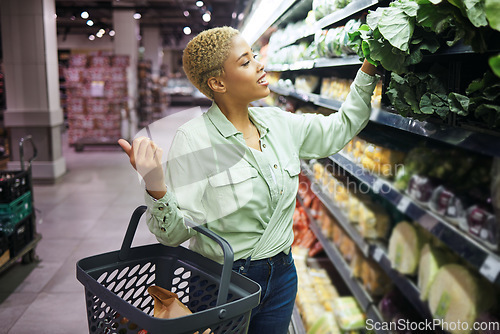 Image of Woman, grocery shopping and vegetables choice, discount and sale or wholesale promotion of healthy food in basket. Happy African customer with spinach in retail, convenience store or supermarket deal