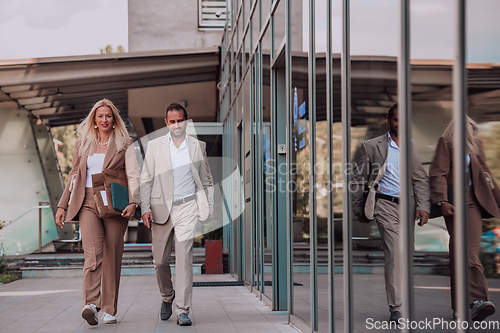 Image of Modern business couple after a long day's work, walking together towards the comfort of their home, embodying the perfect blend of professional success and personal contentment.