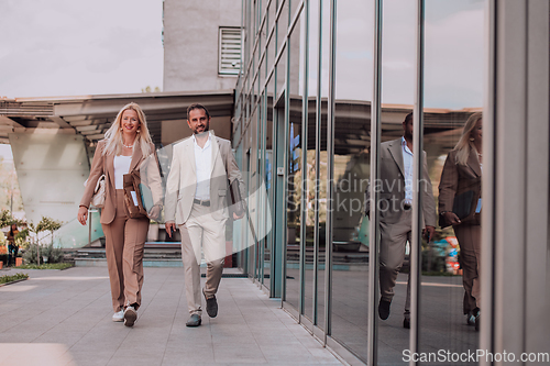 Image of Modern business couple after a long day's work, walking together towards the comfort of their home, embodying the perfect blend of professional success and personal contentment.