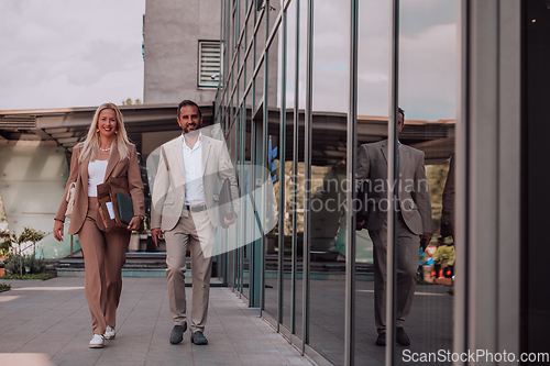 Image of Modern business couple after a long day's work, walking together towards the comfort of their home, embodying the perfect blend of professional success and personal contentment.