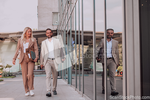 Image of Modern business couple after a long day's work, walking together towards the comfort of their home, embodying the perfect blend of professional success and personal contentment.