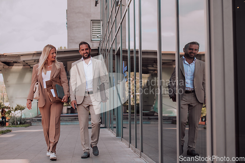 Image of Modern business couple after a long day's work, walking together towards the comfort of their home, embodying the perfect blend of professional success and personal contentment.