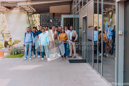 Image of A diverse group of businessmen and colleagues walking together by their workplace, showcasing collaboration and teamwork in the company.