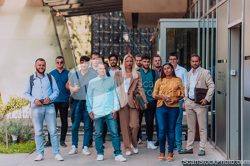 Image of A diverse group of businessmen and colleagues walking together by their workplace, showcasing collaboration and teamwork in the company.