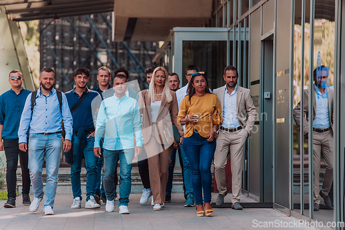 Image of A diverse group of businessmen and colleagues walking together by their workplace, showcasing collaboration and teamwork in the company.