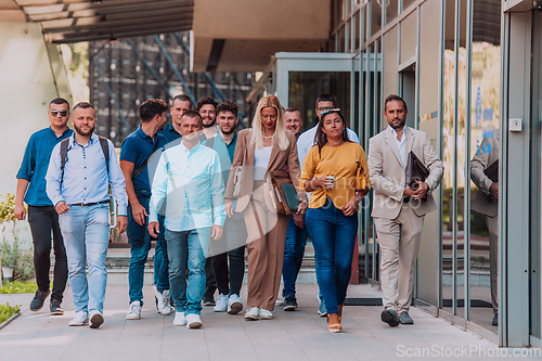 Image of A diverse group of businessmen and colleagues walking together by their workplace, showcasing collaboration and teamwork in the company.