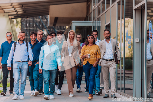 Image of A diverse group of businessmen and colleagues walking together by their workplace, showcasing collaboration and teamwork in the company.