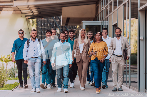 Image of A diverse group of businessmen and colleagues walking together by their workplace, showcasing collaboration and teamwork in the company.