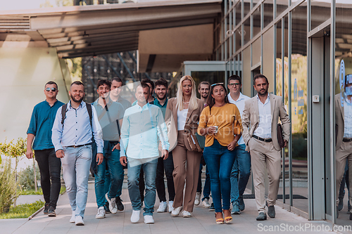 Image of A diverse group of businessmen and colleagues walking together by their workplace, showcasing collaboration and teamwork in the company.