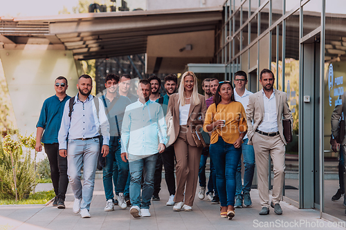 Image of A diverse group of businessmen and colleagues walking together by their workplace, showcasing collaboration and teamwork in the company.