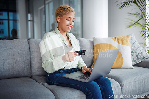 Image of Woman, laptop and credit card for home online shopping, fintech payment and e commerce on her sofa. African person on computer for internet banking, website subscription or application for loan