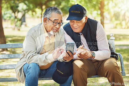 Image of Elderly men, friends and phone in park, reading and army memory with thinking, relax and sunshine. Senior military veteran, smartphone social media and talk on bench, nostalgia and remember service