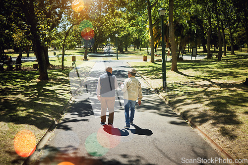 Image of Men, friends walking and talking in park, nature and outdoor in retirement with support, communication or bokeh. Mature, people and back on path in New York with conversation and social community