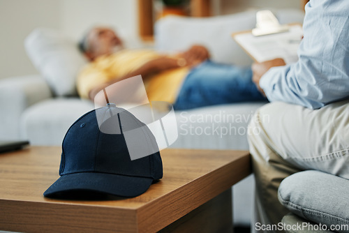 Image of Cap, help and man in therapy for stress, conversation and discussion about mental health. Anxiety, psychology and closeup of hat on table in counseling for advice, notes or support from psychologist