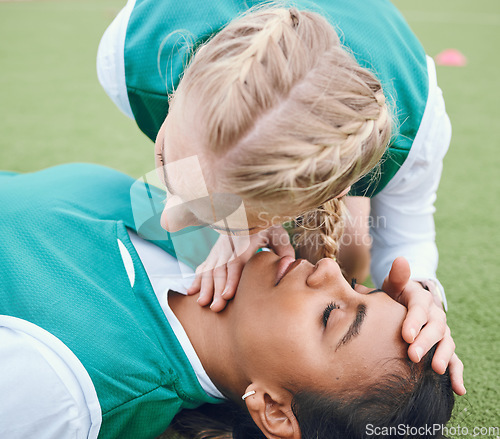 Image of First aid, breathing and emergency with a hockey player on a field to save a player on her team after an accident. Fitness, cpr and heart attack with a woman helping her friend on a field of grass