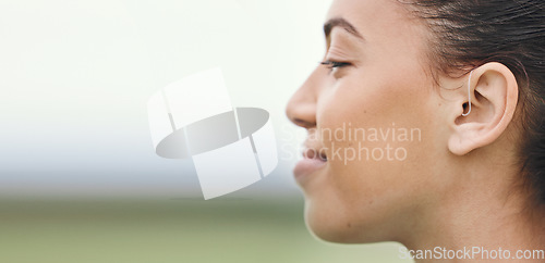 Image of Face, mockup or hearing aid and a sports woman outdoor with an implant for sound or audio improvement. Profile, deaf and happy young athlete with an ear disability or impairment at training on space