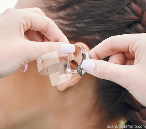 Image of Closeup of hands, hearing aid and ear, person with disability and healthcare, people and medical audio tech for communication. Health, wellness and support, deaf and help with sound waves and implant