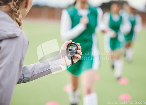 Image of Hands, coach or team with timer on field to monitor time, fitness training or exercise progress. Hockey, performance blur or fast sports athlete with stop watch to check running workout or wellness