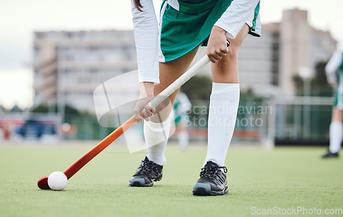 Image of Fitness, legs and hockey stick with a sports person on a court or field during a game for competition. Exercise, grass and ball with a player training at practice on astro turf for health or wellness