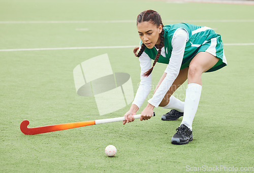 Image of Hockey, sports or woman on turf in fitness training, game or competition with ball, stick or action. Strong, athlete or fit girl player in exercise, workout or motion on artificial grass for power