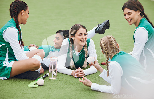 Image of Women, team and hockey player on field, talking and relaxing after match, smile and workout. Conversation, happiness and positive for sports, fitness and exercise together for unity, game and health