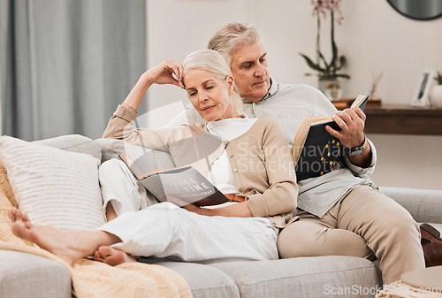 Image of Old people on couch, reading book and relax together at home, retirement and wellness with love and comfort. Trust, care and support in marriage, share hobby with partner for knowledge and story