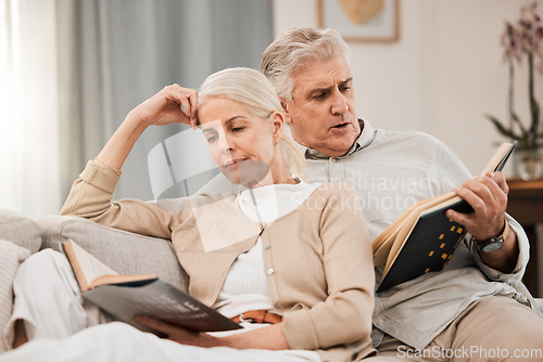 Image of Old couple on sofa, reading book and relax together at home, retirement and wellness with love and comfort. Trust, care and support in marriage, share hobby with partner for knowledge and story