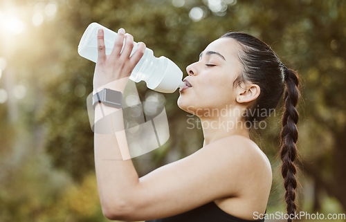 Image of Woman, fitness and drinking water in nature for hydration, natural nutrition or sustainability. Thirsty runner person with mineral drink or bottle in rest after workout, exercise or outdoor training