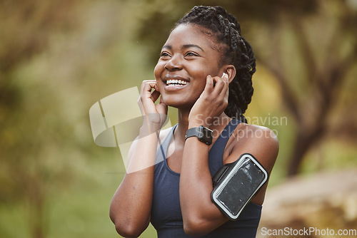 Image of Fitness, smile and black woman listening to music outdoor exercise, workout or training in a forest for wellness. Happy, confident and young person ready and enjoy radio, audio or podcast in nature