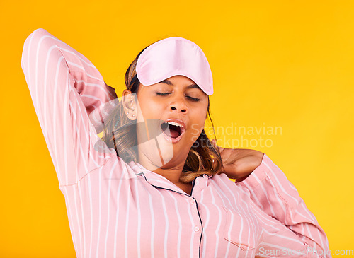 Image of Wake up, yawn and a woman on a yellow background in pyjamas for sleeping, tired and in the morning. Fatigue, young and a girl or person in clothes for rest, comfort and a nap in a studio for night