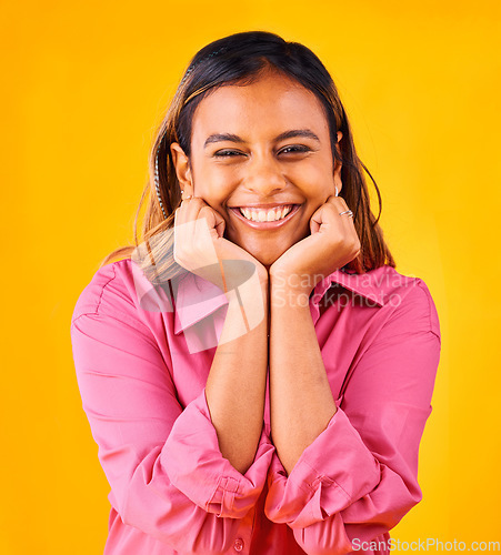 Image of Woman, smile and happy with hands on face, portrait and closeup in studio with yellow background. Indian girl, self love and positive, satisfaction and confidence with hand gesture, style and fashion