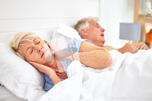 Image of Snoring, problem and woman with frustrated with noise, sound or husband sleeping in bed with wife. Elderly, couple and man snore in sleep in retirement home bedroom and lady with hands on ears