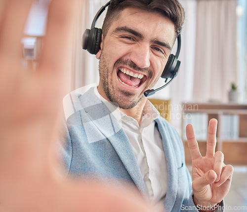 Image of Portrait, selfie or happy man in a call center office on a break to post a photograph on social media online. CRM, peace sign or male sales agent taking fun pictures to relax in workplace with smile