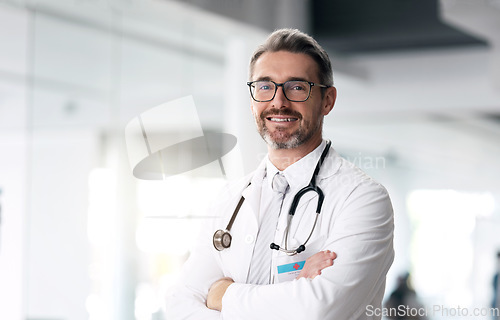 Image of Happy doctor, portrait and man with arms crossed in hospital for healthcare, wellness or career. Face, medical professional smile and confident surgeon, expert or mature employee in glasses in Canada