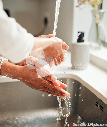 Image of Closeup, hygiene and people washing hands in sink with water for cleaning, faucet or grooming. Zoom, sanitary and morning routine with soap, foam or liquid in basin for fresh fingers in a house