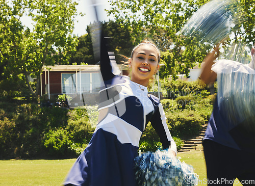 Image of Cheerleader, lead dancer and hand raise in routine for university sport, game or fitness in uniform. Asian girl, energy and team with gymnastics, pom poms and college performance for competition