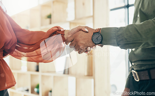 Image of Creative people, handshake and partnership in meeting, b2b deal or teamwork together at office. Closeup of man and woman shaking hands for startup, introduction or thank you in agreement at workplace