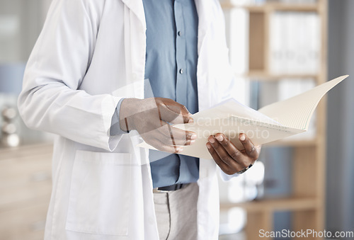 Image of Doctor hands, paperwork and report in closeup for reading, analysis or study for wellness in hospital. Healthcare expert, medic and folder for documents, life insurance or check information in clinic