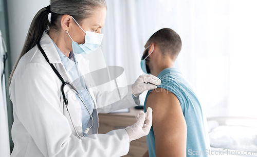 Image of Hospital, doctor and patient with injection after examination at clinic for treatment, cure or flu shot. Healthcare, medicine or vaccine for prevention, immunity or virus with mask for protection
