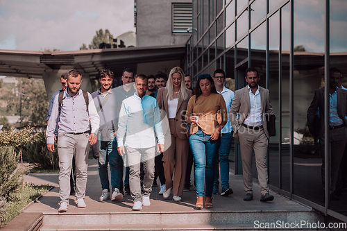 Image of A diverse group of businessmen and colleagues walking together by their workplace, showcasing collaboration and teamwork in the company.