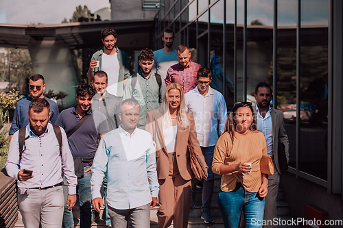 Image of A diverse group of businessmen and colleagues walking together by their workplace, showcasing collaboration and teamwork in the company.