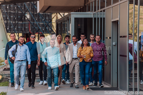 Image of A diverse group of businessmen and colleagues walking together by their workplace, showcasing collaboration and teamwork in the company.