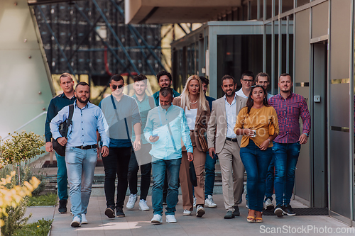 Image of A diverse group of businessmen and colleagues walking together by their workplace, showcasing collaboration and teamwork in the company.