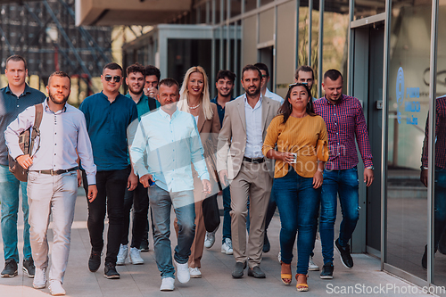 Image of A diverse group of businessmen and colleagues walking together by their workplace, showcasing collaboration and teamwork in the company.