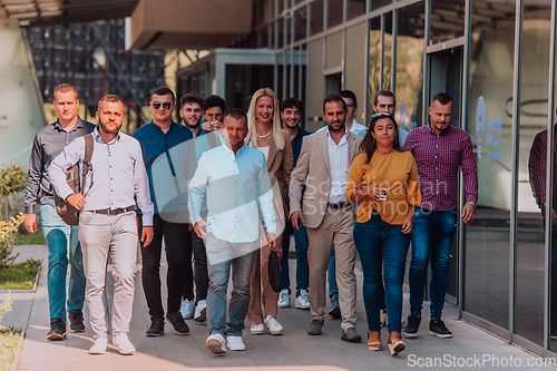 Image of A diverse group of businessmen and colleagues walking together by their workplace, showcasing collaboration and teamwork in the company.