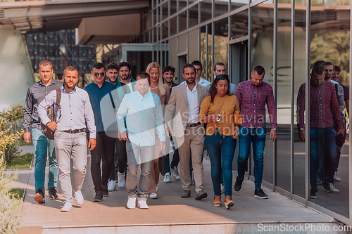 Image of A diverse group of businessmen and colleagues walking together by their workplace, showcasing collaboration and teamwork in the company.