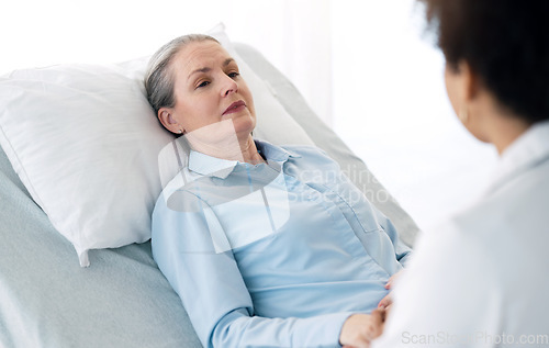 Image of Hospital, doctor and mature patient with care, comfort and empathy for diagnosis news in bed. Healthcare, clinic and health worker with woman holding hands for support, wellness and medical results