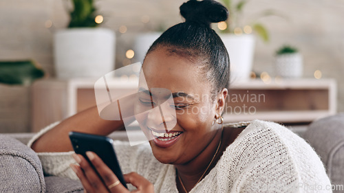 Image of Funny, black woman and using phone with smile in home or social media, mobile app and communication online. internet, meme or person on couch streaming video or comedy on cellphone in living room